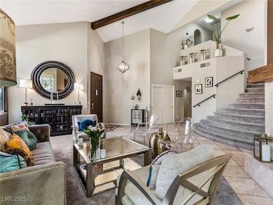 Living room featuring high vaulted ceiling and bea