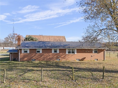 Back of house with brick siding and a chimney