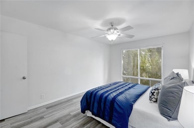 Bedroom with baseboards, a ceiling fan, and wood 