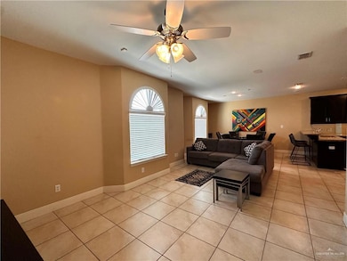 Living area with light tile patterned floors and ceiling fan