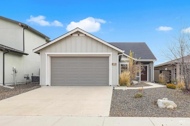 Single story home with board and batten siding, concrete driveway, an attached garage, and a shingled roof