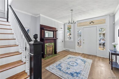 Foyer featuring ornamental molding, a chandelier, and light wood-type flooring