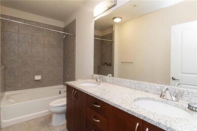 Full bathroom featuring shower / tub combination, double vanity, and light tile patterned floors