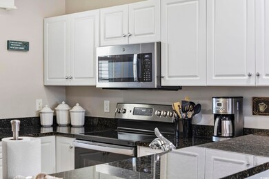 Kitchen with dark stone countertops, stainless ste