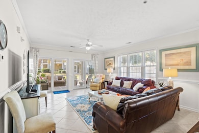 Living room featuring french doors, a textured ceiling, light tile patterned floors, ornamental molding, and ceiling fan