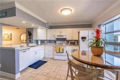Kitchen with white cabinetry, sink, white applianc