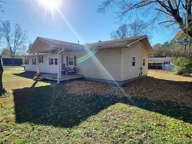 Rear view of house with a yard and a deck