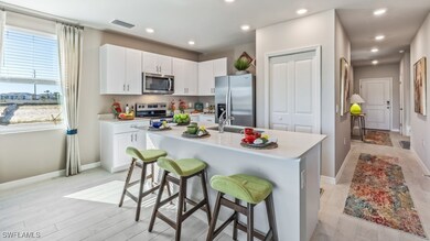 Kitchen with white cabinetry, sink, a breakfast ba