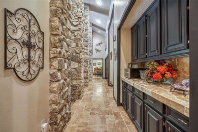 View of the front hallway showing the floor to ceiling stone columns and incredible storage and workspace.
