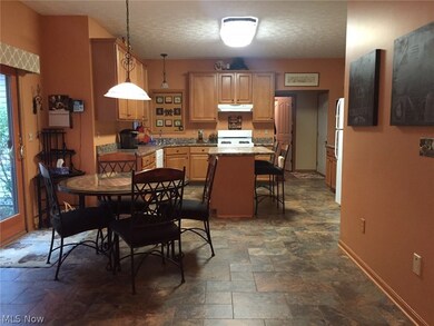 Huge eat in kitchen features maple cabinets and slider to the beautiful patio and private trails leading to the scenic river.