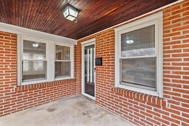 View of front door- window to the right is to the living room and the window on the left is to the sunroom