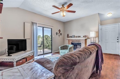 Living room with a fireplace, a textured ceiling,