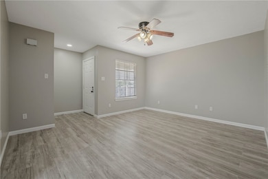 Empty room with light wood finished floors and ceiling fan