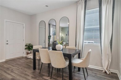 Dining space with dark wood-type flooring and baseboards