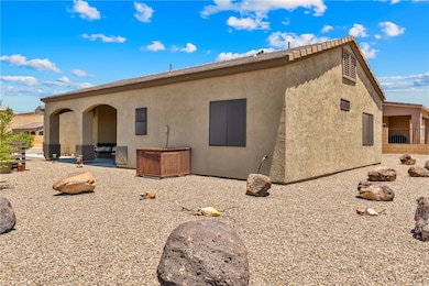 Side of property with stucco siding and a patio ar