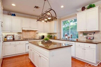 Gourmet kitchen with granite counters opens to a s