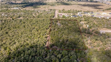 View of property location with a heavily wooded area and property boundaries highlighted