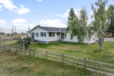 Single story home with a fenced backyard, a shingled roof, a rural view, a mountain view, and a chimney