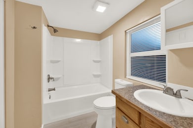 Full bath featuring bathtub / shower combination, vanity, and light wood finished floors