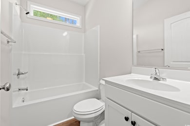 Full bath with vanity, toilet, and  shower combination