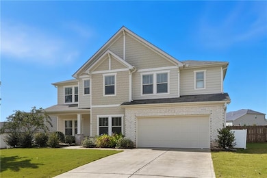 Craftsman-style house with a porch, driveway, an attached garage, and brick siding