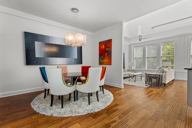 Dining space featuring crown molding, ceiling fan with notable chandelier and hardwood/wood-style flooring