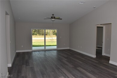 Spare room featuring lofted ceiling, visible vents, dark wood finished floors, and baseboards
