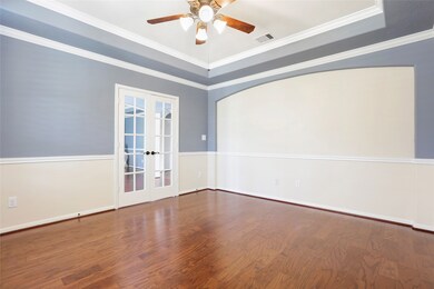 The spacious office has french doors, a ceiling fan and lots of cool architectural details.