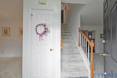 Entryway with light carpet and stairs