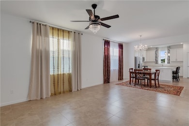 Dining space featuring healthy amount of natural light, a chandelier, ceiling fan, and light tile patterned flooring