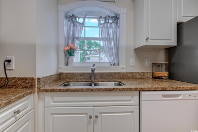 Kitchen featuring dishwasher, white cabinetry, and light stone countertops