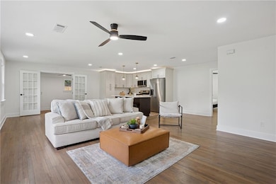 Living area featuring ceiling fan, dark wood-type flooring, recessed lighting, and french doors