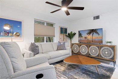 Living area with ornamental molding, wood finished floors, and ceiling fan