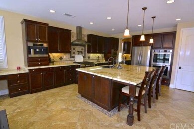 Huge chef's kitchen w/high end appliances, over-sized island, & pendant lighting.
