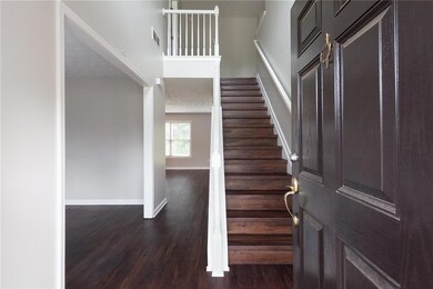 Foyer entrance featuring a towering ceiling, dark wood finished floors, and stairway