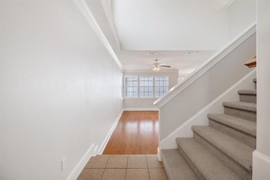 Stairway with ceiling fan, baseboards, crown mold