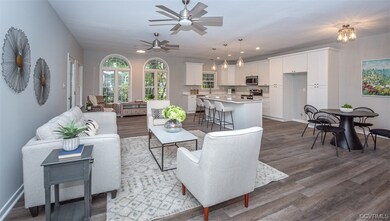 Open living room with ceiling fans, arched windows