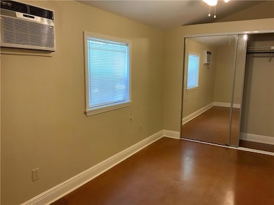 Bedroom #1:  Light filled bedroom has ample closet space, scored cement floors, ceiling fan and wall unit for heating and cooling.