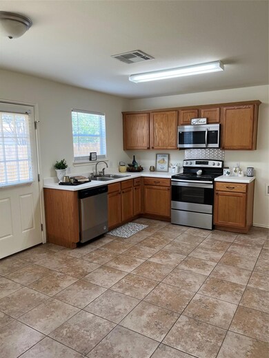 Kitchen with range, dishwasher, brown cabinetry, 