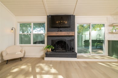 Living room featuring a brick fireplace and wood finished floors