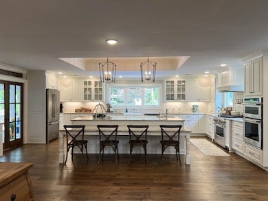 Kitchen featuring a chandelier, white cabinetry, h