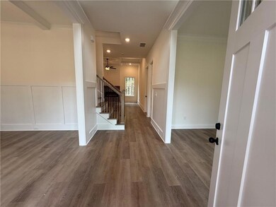Entrance foyer with a decorative wall, dark wood-style flooring, stairway, recessed lighting, and crown molding