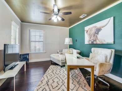Office featuring dark wood-style flooring, crown molding, and a ceiling fan