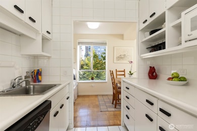 Galley kitchen has a modern, efficient feel and looks towards the surrounding trees.