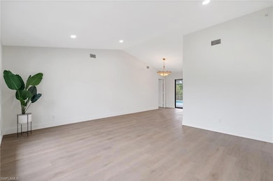 Spare room with recessed lighting, vaulted ceiling, visible vents, and light wood-type flooring