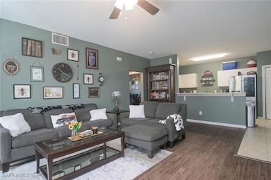 Living room with ceiling fan and dark hardwood / w
