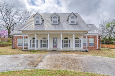 View of front of home with covered porch, brick si