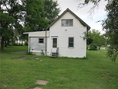 Back of property with entry steps and a lawn