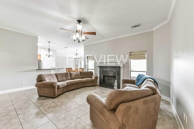 View of living room, gas log fireplace, dining area and kitchen