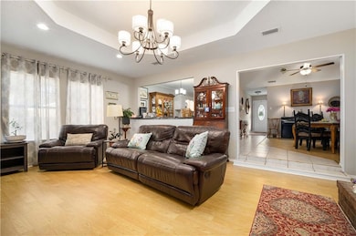 Living area featuring a raised ceiling, light wood